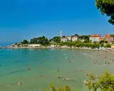 Una giornata di sole sulle spiagge Croazia, con gente che nuota e si rilassa nell'acqua cristallina.