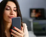 Zastanawia się, czy muszę odbierać telefon od ojca dziecka. Wyraz twarzy sugeruje niepewność.