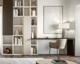 Angolo studio in soggiorno ricavato da libreria componibile. Scrivania integrata, sedia, lampada e quadro astratto.