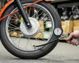 Sprawdzanie ciśnienia w oponach motocykla. Manometr pokazuje aktualne wartości, pomocny przy odczycie z tabeli ciśnienia w oponach.