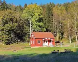 Rött hus i Svartedalen, perfekt för en vandring. Höstfärger i skogen och en solig äng.