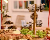 Deliciosa merienda de cumpleaños para adultos: donuts, quesos, frutos secos y uvas.