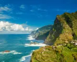 Grüne, steile Küsten mit kleinen Häusern, die sich an den Hang schmiegen. Das azurblaue Meer brandet an Felsen. Ja, Madeira in der EU bietet diese atemberaubende Aussicht.