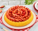 Una deliziosa crostata morbida alle fragole, con la sua base dorata e un abbondante strato di fragole fresche affettate.