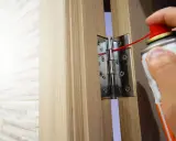Smarowanie zawiasów drzwi wejściowych, aby zapobiec skrzypieniu. Użyj smaru w sprayu, aby ułatwić otwieranie i zamykanie.