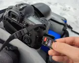 Dłoń wkłada kartę pamięci 64GB do aparatu. Ile to zdjęć? Z pewnością mnóstwo!