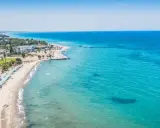 Piękna plaża na wyspie Kos z turkusową wodą, leżakami i palmami. Idealne miejsce na wakacje.