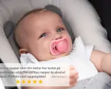 Söt bebis med rosa napp i munnen, som verkar nöjd. En recension lyfter fram nappens kvalitet.