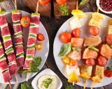 Fleisch- und Fischspieße mit Gemüse und Dip – perfekt, wenn man fragt, was man zum Grillen mitbringt.