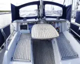 Cockpit d'un Nauticat 33 avec table en teck ornée d'une rose des vents. Détails techniques visibles.