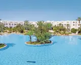 Słoneczny basen w Djerba Resort (dawniej Vincci) otoczony palmami i białymi budynkami.