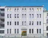 Nowoczesny, biały budynek kliniki Balticmed w Szczecinie z podświetlanym logo i oknami.