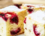 Puszyste ciasto z owocami, posypane cukrem pudrem, kusi soczystymi wiśniami. Idealne na deser!