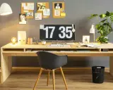 Ein moderner Arbeitsplatz, inspiriert vom Gedanken, einen **kinderschreibtisch selber bauen** zu wollen. Helle Holzmöbel, Pflanzen und eine Pinnwand schaffen eine kreative Atmosphäre.