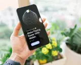 Dłoń trzyma iPhone'a z aplikacją Wallet, która ułatwia płatności dzięki technologii NFC.