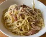 En krämig portion pasta carbonara med knapriga bitar av fläsk och rikligt med svartpeppar.