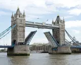 Torre de Londres con sus **puentes levadizos** abiertos, permitiendo el paso de barcos por el río Támesis.