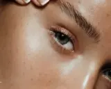 Un gros plan sur un œil avec des lentilles bleues et des sourcils parfaitement définis après un soin pour teindre sourcils.