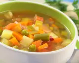 Miseczka pełna warzyw, idealna na dietę zupową. Marchewka, ziemniaki, groszek i fasolka w aromatycznym bulionie.
