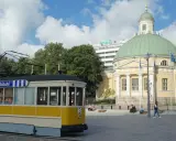 Żółty tramwaj na tle katedry i nowoczesnego budynku. Turku atrakcje to nie tylko zabytki, ale i miejska komunikacja.