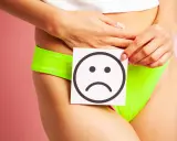Kobieta z kartką i smutną buźką symbolizującą problem z nietrzymaniem moczu. Rozwiązaniem może być laserowe leczenie nietrzymania moczu.