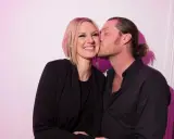 Sanna Nielsen ler när en man med hästsvans ger henne en puss på kinden.