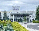 Budynek Centrum Onkologii w Bydgoszczy z zielenią przed wejściem.