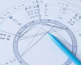 Zbliżenie na astrologia wedyjska kosmogram z niebieskim długopisem wskazującym na wykres.