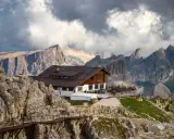 Rifugio alpino in Alto Adige, con sentiero metallico e imponenti vette sullo sfondo.
