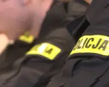 Zbliżenie na rękawy mundurów policyjnych z żółtymi naszywkami "POLICJA".
