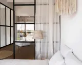 Verre et rideaux pour séparer une petite chambre en deux, créant des espaces distincts et lumineux.