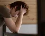 En person med händerna i håret, ser nedåt. Kanske en bild som visar hur man kan tänka kring hur minskar man stress.