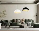 Nowoczesny salon z zieloną sofą i dwoma wiszącymi lampami, które idealnie pasują jako żyrandol do salonu.