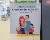 Plakat informujący o honorowaniu Karty Dużej Rodziny z rysunkiem rodziny.