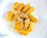 Pyszne kopytka z dyni, polane masłem i posypane parmezanem, tworzą jesienną ucztę.