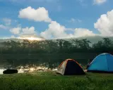 Dwa namioty nad jeziorem o wschodzie słońca. To mogą być najpiękniejsze pola namiotowe w Polsce.