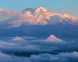 Elbrus, najwyższy szczyt Kaukazu, lśni w blasku wschodzącego słońca, otoczony morzem chmur.