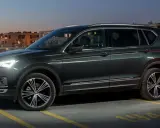 Ciemnozielony SUV, jeden z najbardziej polecanych samochodów 7-osobowych, zaparkowany na dachu parkingu nocą.