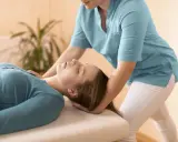 Fizjoterapeuta delikatnie masuje mięsień obojczykowo sutkowy pacjentki, przynosząc ulgę.
