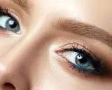 Nahaufnahme eines blauen Auges mit braunem Lidschatten und blauer Eyeliner-Linie. Perfekt für die Frage: welche haarfarbe bei blauen augen.