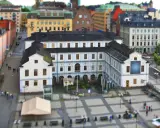 En vy över stadsmuseet i Stockholm med omgivande byggnader och en öppen plats med människor.