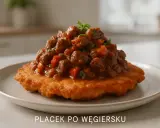 Placek po węgiersku: złocisty placek ziemniaczany z bogatym gulaszem mięsnym i warzywami, udekorowany natką pietruszki.