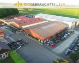 Luftaufnahme eines Autoteile-Lagers mit Gebäuden und vielen Autos.