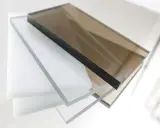 Stapel von transparenten und braunen Polycarbonatplatten. Die Kanten zeigen die Dicke und die Möglichkeit, Polycarbonat zu lackieren.