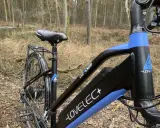 Rower elektryczny z rozładowaną do zera baterią litowo jonową, gotowy do ładowania po leśnej przejażdżce.