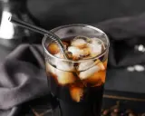 Erfrischender Cold Brew Kaffee in einem Glas mit Eiswürfeln und einem Metallstrohhalm. Perfekt für heiße Tage.