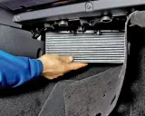 Wymiana filtra kabinowego Skoda Octavia 2. Dłoń wyjmuje filtr z obudowy pod deską rozdzielczą.