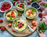 Vier Gläser mit selbstgemachtem Pudding, garniert mit frischen Beeren und Minze. Ein Genuss für Augen und Gaumen!
