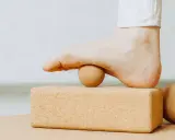 Fuß mit Ball auf Korkblock für Plantarfasziitis Dehnen.