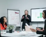 Zespół omawia strategię rozwoju, w tym automatyzację testów oprogramowania. Na tablicy widać KPI, NPS, CSI i SLA.